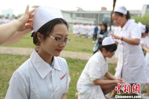 前辈为医学生戴上护士帽。.jpg 前辈为医学生戴上护士帽。.jpg