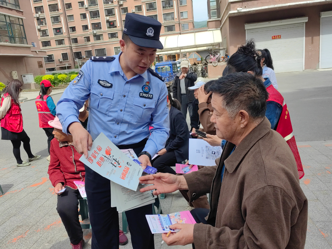 摄影：卢兆国；志愿者和民警向居民科普毒品危害.jpg