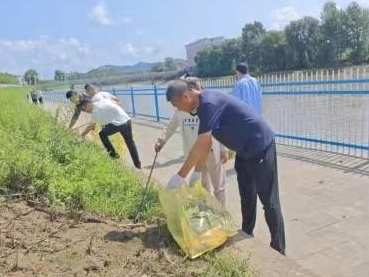 辉南县样子哨镇组织全体机关干部到河边拾捡垃圾